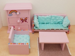 Zestaw mebelków z motywem tęczowego jednorożca – drewniane meble dla lalek w kolorze różowym, ozdobione tęczami i jednorożcami.