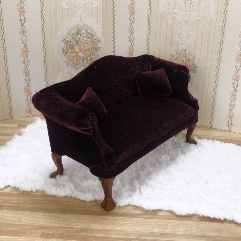 miniaturowa śliwkowa sofa z dwoma poduszeczkami